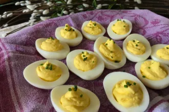 Eleven deviled eggs on a cloth placemat.