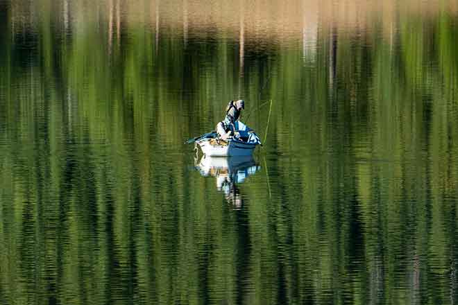 PROMO Outdoors - Boat Fishing Lake Trees Fisherman - iStock - Sparty1711