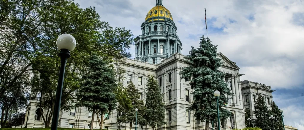 PROMO HIRES Colorado State Capitol Building - fotoguy22 - iStock - 1468912821 Colorado State Capitol building with green trees and golden dome.