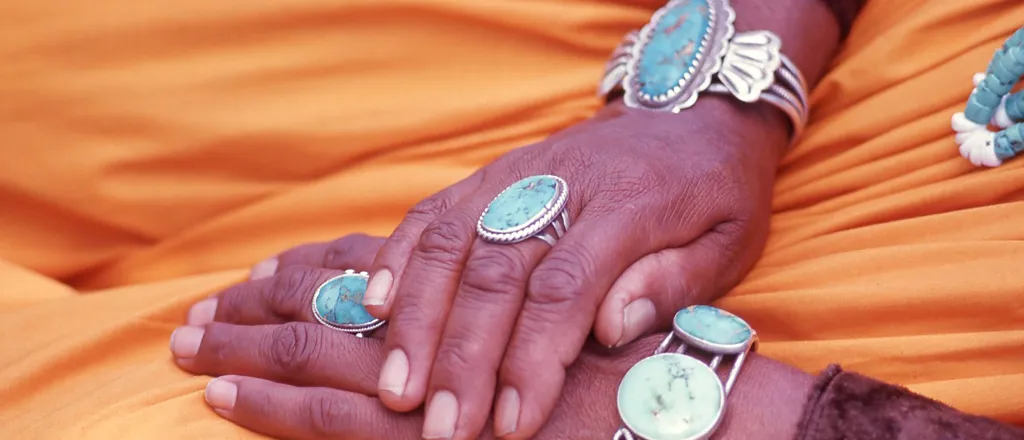 Navajo weaver's hands with turquoise jewelry - Rebecca J Becker - iStock-1251580456 Navajo weaver's hands with turquoise jewelry - Rebecca J Becker - iStock-1251580456