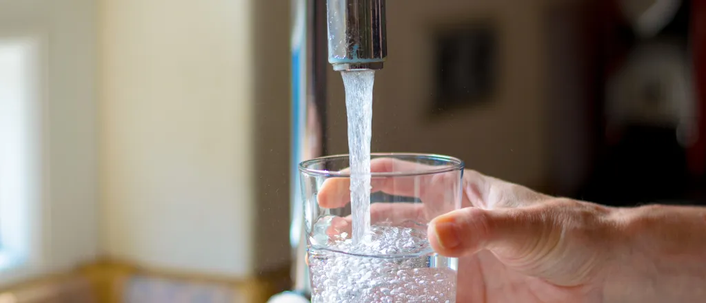 PROMO HIRES Water Faucet Tap Drinking Glass Drought - mheim3011 - iStock-544332118 Hand filling a glass with water from a faucet.