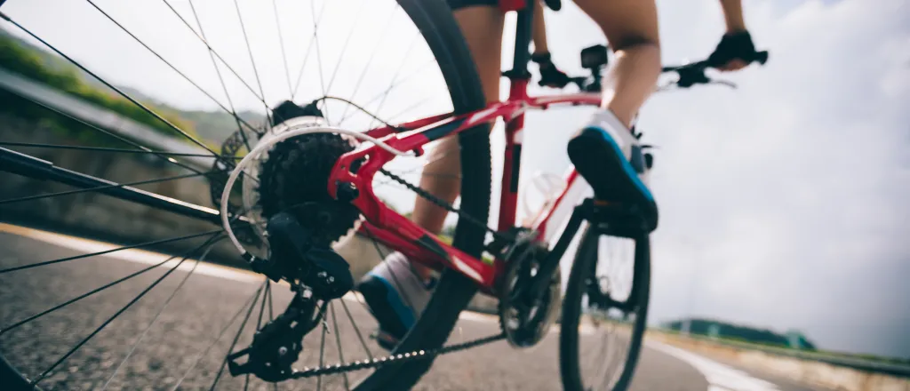 PROMO HIRES Transportation - Bicycle Bike Rider Outdoors Vehicle - iStock - lzf Low angle view of a bicycle with rider traveling on a paved surface