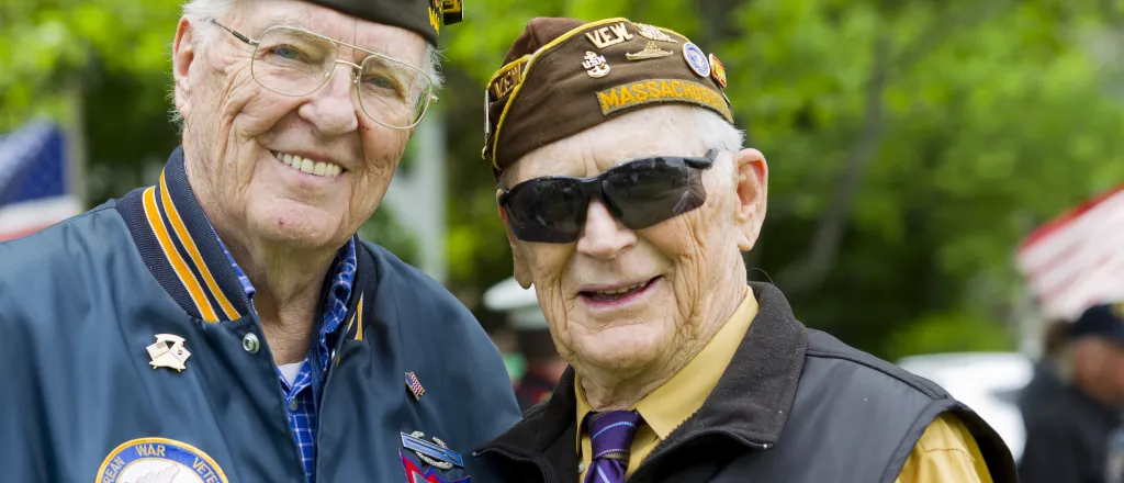 Two United States military veterans wearing medals and uniform hats - flySnow - iStock-507449191