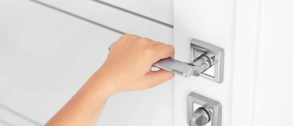 A child grabbing the door handle to an interior door. There is a bolted lock and they are trying to open the door. A child grabbing the door handle to an interior door. There is a bolted lock and they are trying to open the door.