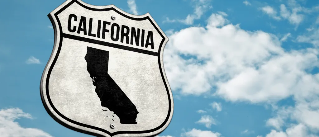 PROMO HIRES Map - California Road Sign Map State - iStock - gguy44 Road sign with the word "California" and a silhouette of the state. A cloudy sky is in the background.
