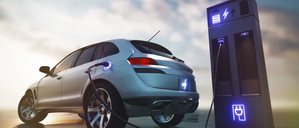 PROMO HIRES Transportation - Electric Vehicle Car EV Charging - UniqueMotionGraphics - iStock-1477067152 Electric car at a charging station with clouds in the background