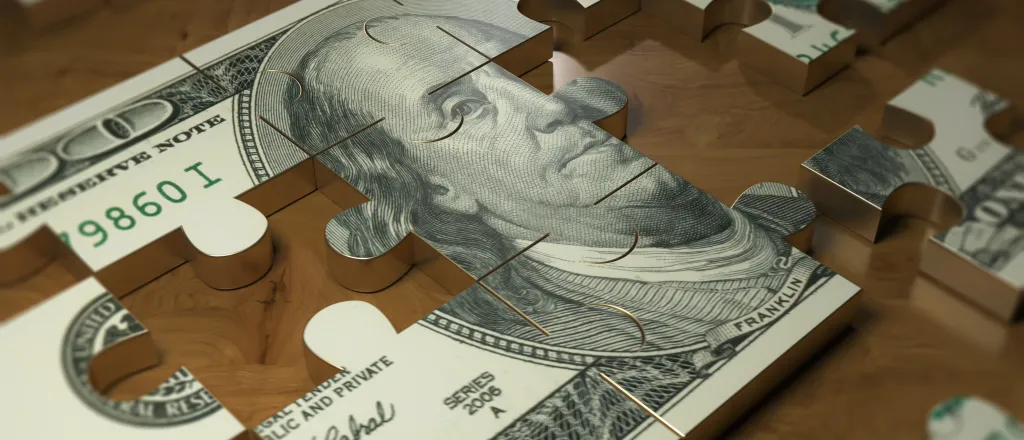 PROMO HIRES Money - Personal Finance Cash Puzzle - iStock - Baris-Ozer Metal puzzle of a United States one hundred dollar bill with pieces removed or missing.