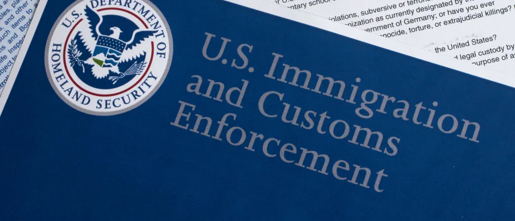 PROMO HIRES Immigration - Law Enforcement - Immigration and Customs Enforcement - danielfela - iStock-507873830 Overhead closeup of documents. The top document is entitled "U.S. Immigration and Customs Enforcement" with the United States Department of Homeland Security logo.