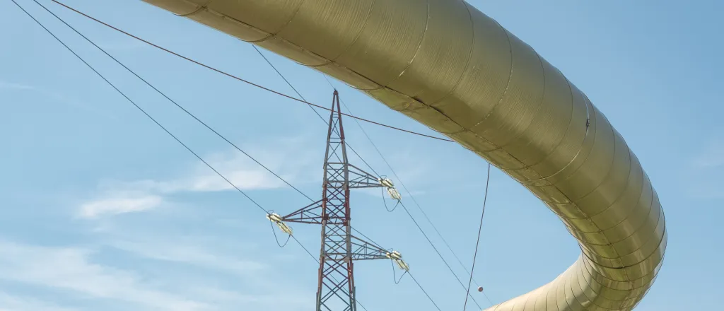 Pipeline representing geothermal energy with a high voltage power line in the background.