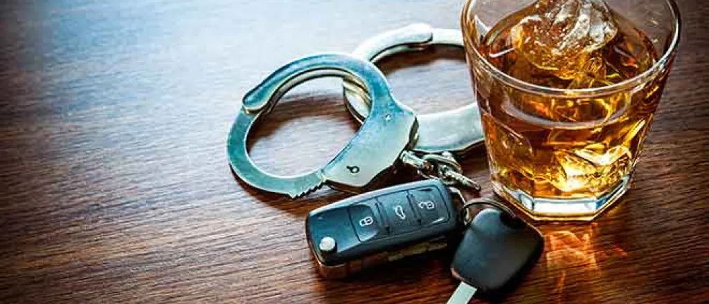 Crime - Drink Drive Whiskey Alcohol Key Fob Handcuff Table Glass - iStock - AlexRaths