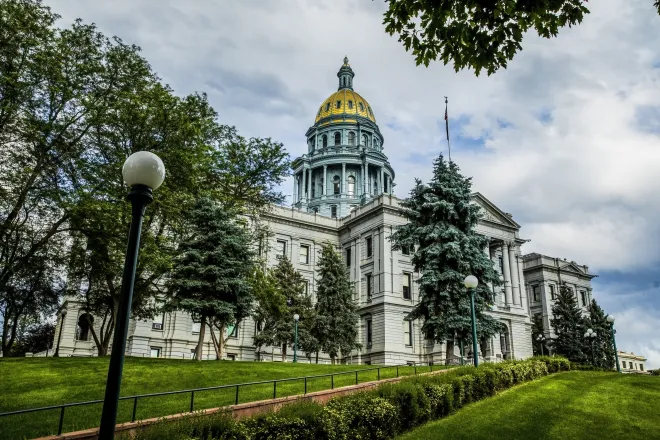 Colorado State Capitol building with green trees and golden dome.