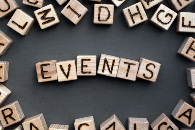 Assorted wooden block with letters on the sides, surrounding the word "events" on wooden blocks