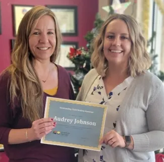 Two people with an award plaque.