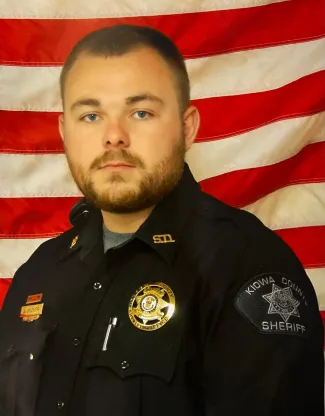 Sergeant Avery Snover posing in uniform in front of a United States flag.