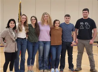 Students standing in a line in an auditorium.