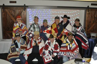 Quilts of Valor recipients. Group of veterans wearing quilts.