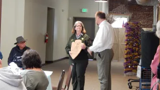 Janet Frederick receiving a plaque from the National Park Service. People at an award ceremony.