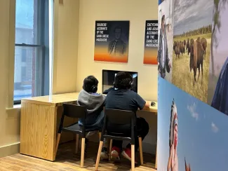 Children examining part of an interactive exhibit at the Sand Creek Massacre visitor center.