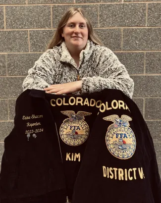 Elaine Shannon posing with Future Farmers of America items.