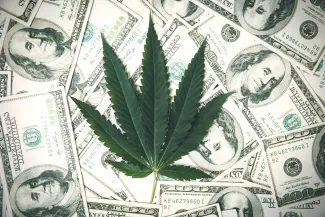 PROMO HIRES Miscellaneous - Marijuana Drugs Dollar Money - iStock - pcess609 Marijuana leaf over scattered United States one hundred dollar bills