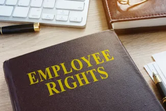 PROMO HIRES Business - Labor Union Employee Rights Job Desk Keyboard Pen - designer491 - iStock-931431806 Book titled "Employee Rights" on a desk near pens, a computer keyboard, and another book
