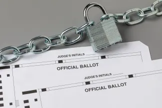 PROMO HIRES Election - Ballot Security Vote Politics Government - JJ Gouin - iStock-2170878039 Two election ballots with a padlock and chain representing election security