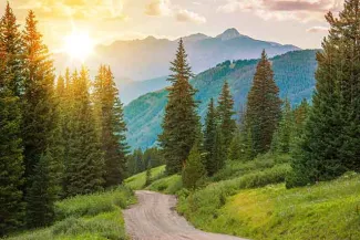 PROMO Outdoors - Mountains Trees Road Landscape Sun - iStock - welcomia