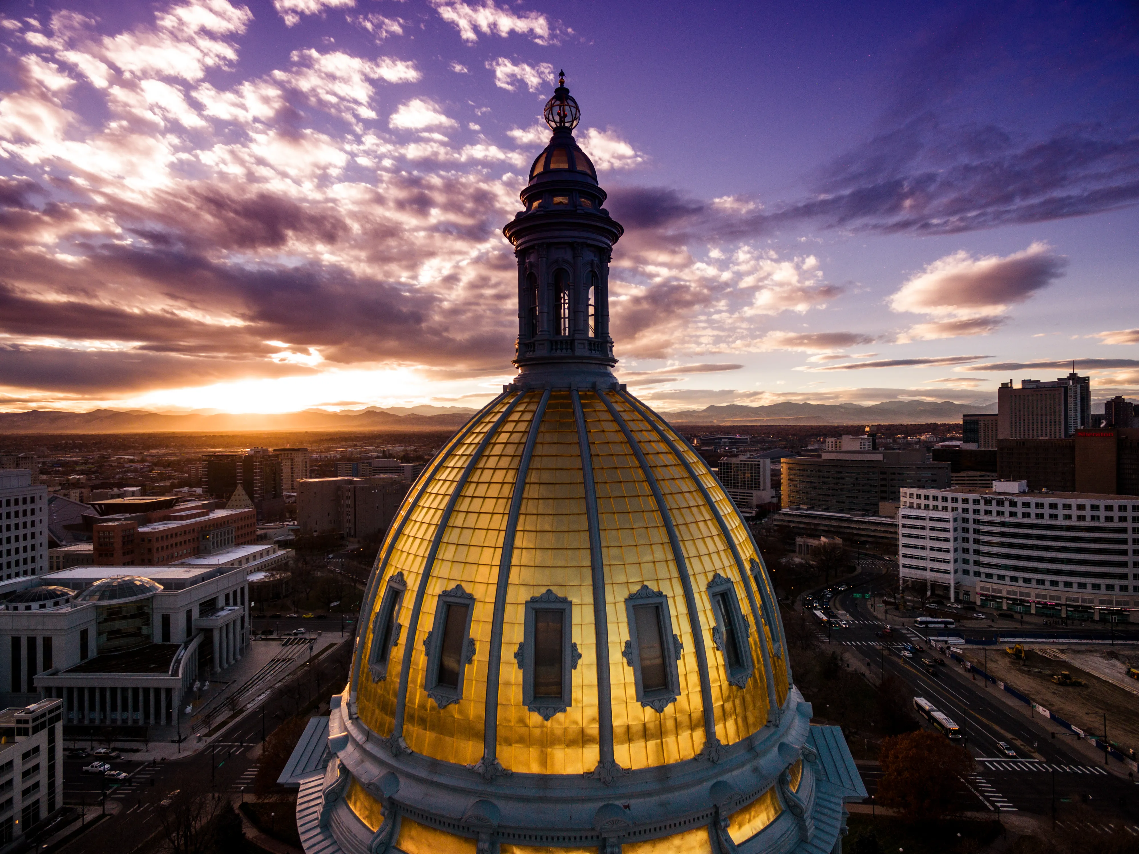 Aerial view of the Colorado capitol building dome with clouds at sunset.