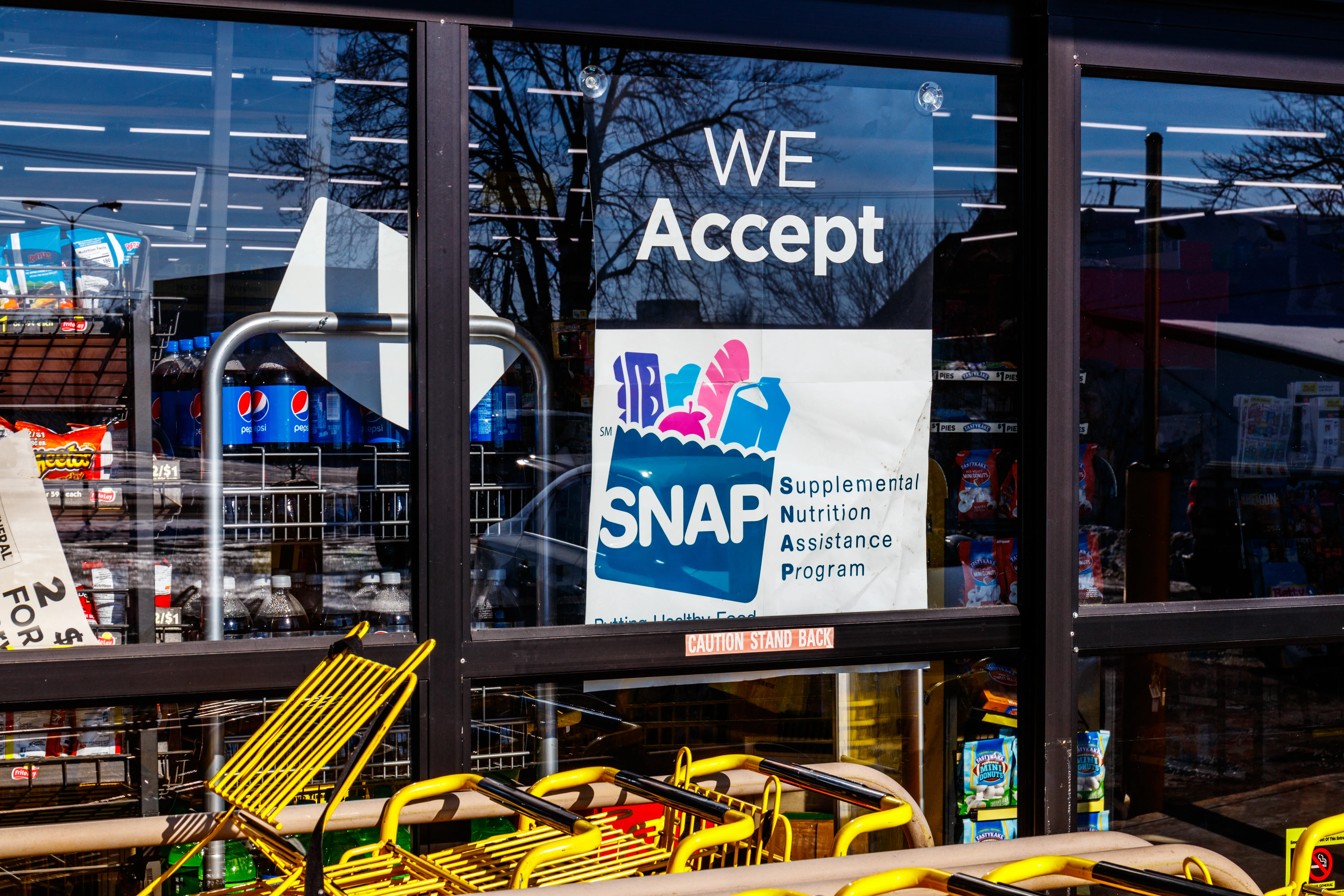 Sign in the window of a store stating that Supplemental Nutrition Assistance Program (SNAP) benefits are accepted.