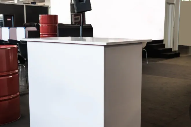 A setup of a marketing booth at a trade show with a stand and several other blank white components.