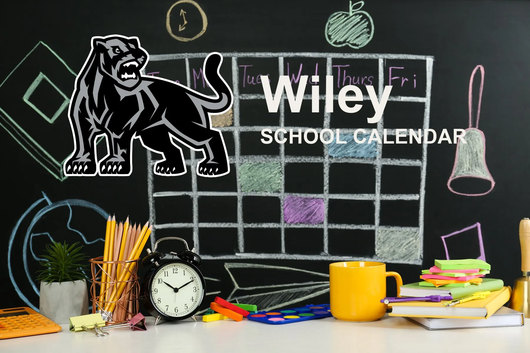 The Wiley School Panthers mascot, beside a chalkboard drawn with a weekly calendar grid above a desk of pencils, a clock and notebooks. The board reads “Wiley School Calendar”.
