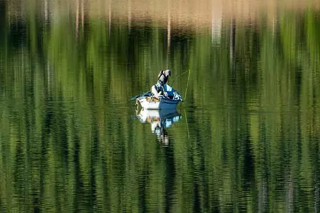 PROMO Outdoors - Boat Fishing Lake Trees Fisherman - iStock - Sparty1711