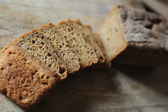 Mixed grain bread Partially sliced loaf of mixed grain bread.