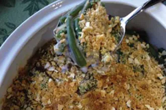 Green Bean Casserole - USDA Serving bowl of green bean casserole with spoonful held above.