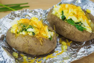 Spinach Stuffed Potatoes - USDA Two spinach stuffed potatoes on a sheet of foil.