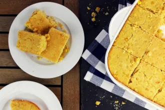 Corn Bread - USDA Plate with three squares of corn bread next to a baking dish of corn bread on a cloth.