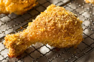 Crispy Oven-Fried Chicken - USDA A leg of crispy oven-fried chicken on a cooling rack.