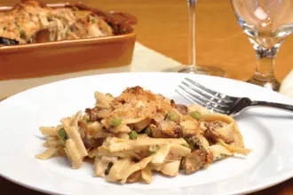 Turkey Tetrazzini - USDA Plate of Turkey Tetrazzini with a fork, next to a serving dish and goblet of water.