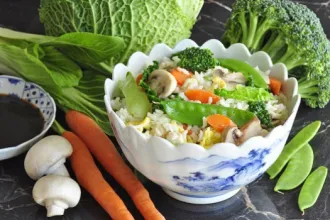 Fried Rice - USDA Bowl of fried rice, topped with, and surrounded by, fresh vegetables.