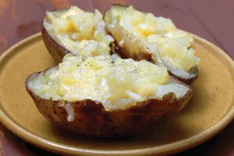 Stuffed potatoes - USDA Stoneware plate with 3 stuffed potato halves.