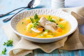 Walleye Chowder - USDA Bowl of walleye chowder on a cloth next to a spoon