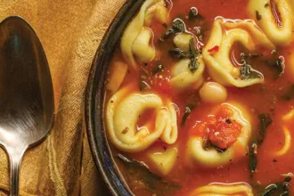 PICT RECIPE Tortellini Soup - USDA Close up of a bowl of tortellini soup next to a spoon
