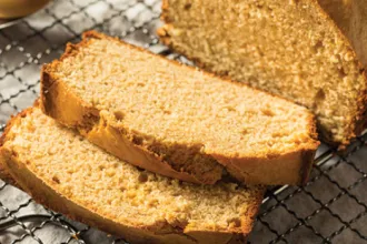 Three-Grain Peanut Bread - USDA Loaf of three-grain peanut bread on a cooling rack with two pieces sliced off.