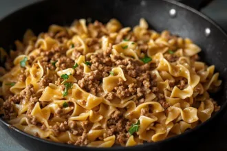 Closeup view of a pan containing cooked beef and noodles.