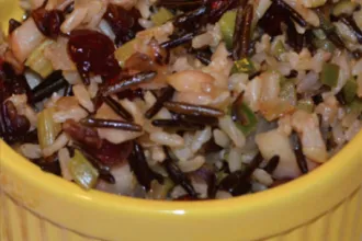 Close up view of apple-sage wild rice stuffing in a bowl.