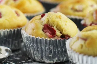Close up view of a fruit muffin with additional muffins partially visible.